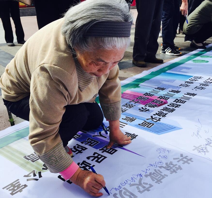 《感恩》白发苍苍的老人将心里话记在留言薄上：“感恩国家对我们的关怀，感恩一切”。(徐菱)_副本.jpg